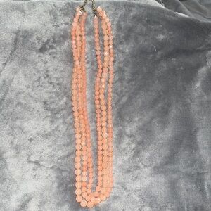 Triple pink long beaded necklace with gold colored clasp